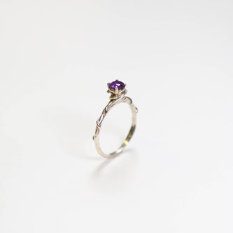 This exquisite ring, with its intricate vine design, measures a delicate 2.5mm in width. Adorning the centre is a stunning 5mm round faceted Amethyst gemstone.