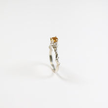 This exquisite ring, with its intricate vine design, measures a delicate 2.5mm in width. Adorning the centre is a stunning 5mm round faceted Citrine gemstone.