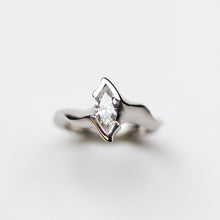 Featuring a stunning platinum tapered band, hand carved in Jeremy's signature asymmetric style, which presents an exquisite 0.60pt marquise diamond.