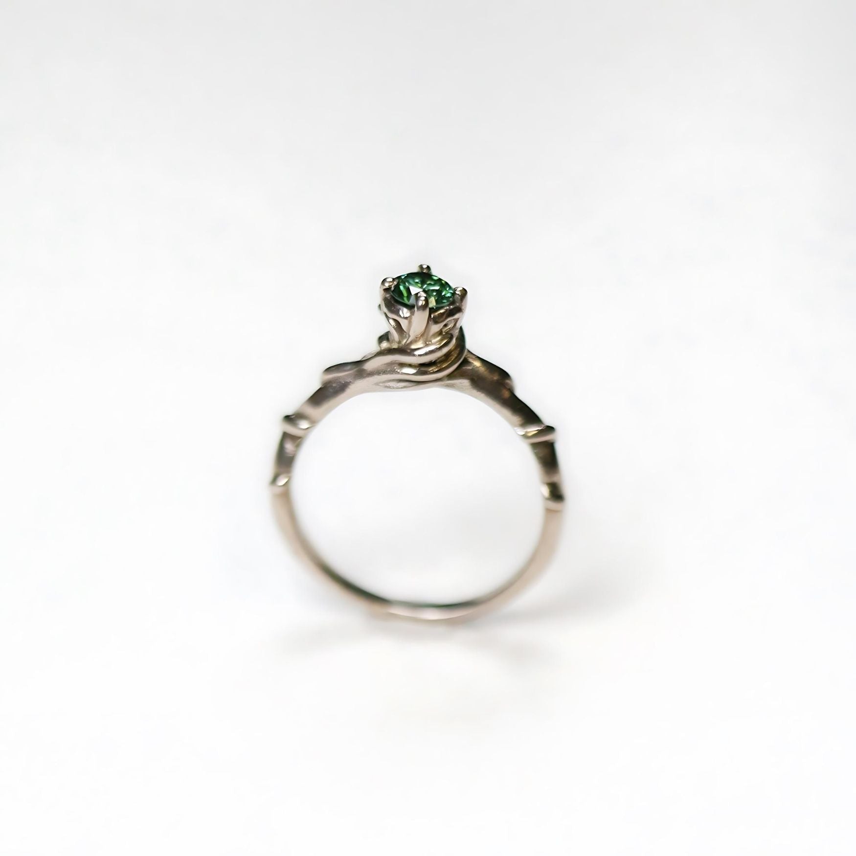 18ct white gold entwine engagement ring with a green diamond