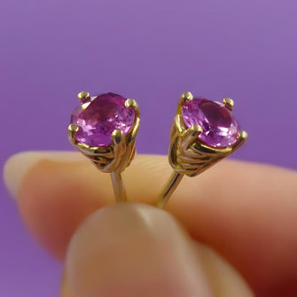 These exquisite earrings are handmade in 18ct yellow gold and feature two stunning .50pt round pink sapphires, totalling 1 carat. The rich, vivid hue of the sapphires is beautifully complemented by the warm glow of the yellow gold, creating a look that is both bold and elegant.