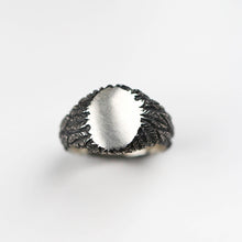 This striking oval signet ring, crafted in sterling silver, showcases intricate hand-carved feather detailing that adds a touch of natural elegance. Designed to be a statement on its own, it also offers the option for personalisation with a custom-engraved family crest, logo, symbol, or initials, making it a truly unique and personal piece of jewellery.