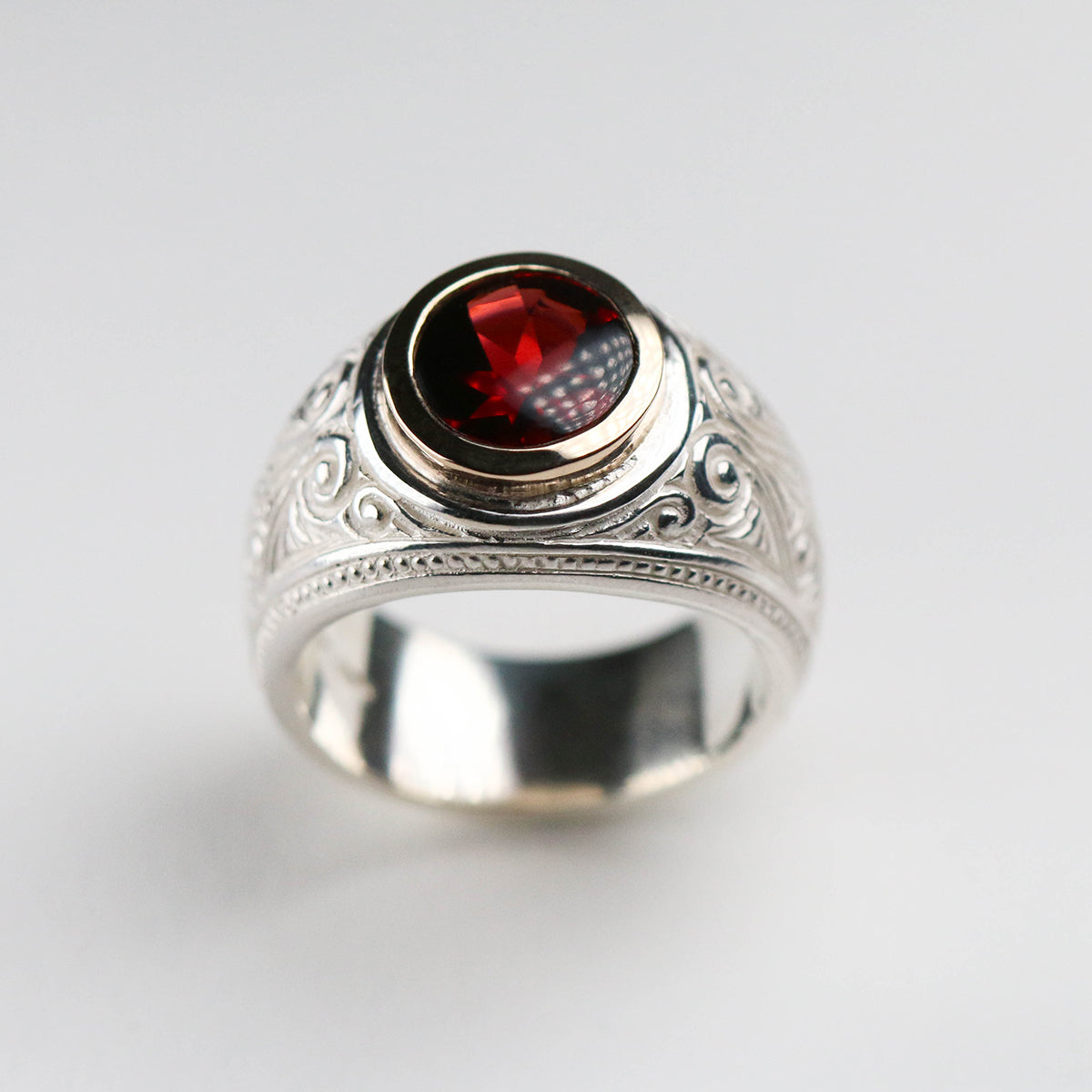 A brand new piece by Jeremy Hoye. This silver college style ring is handmade in solid silver with a 9ct yellow gold setting and oval garnet stone.