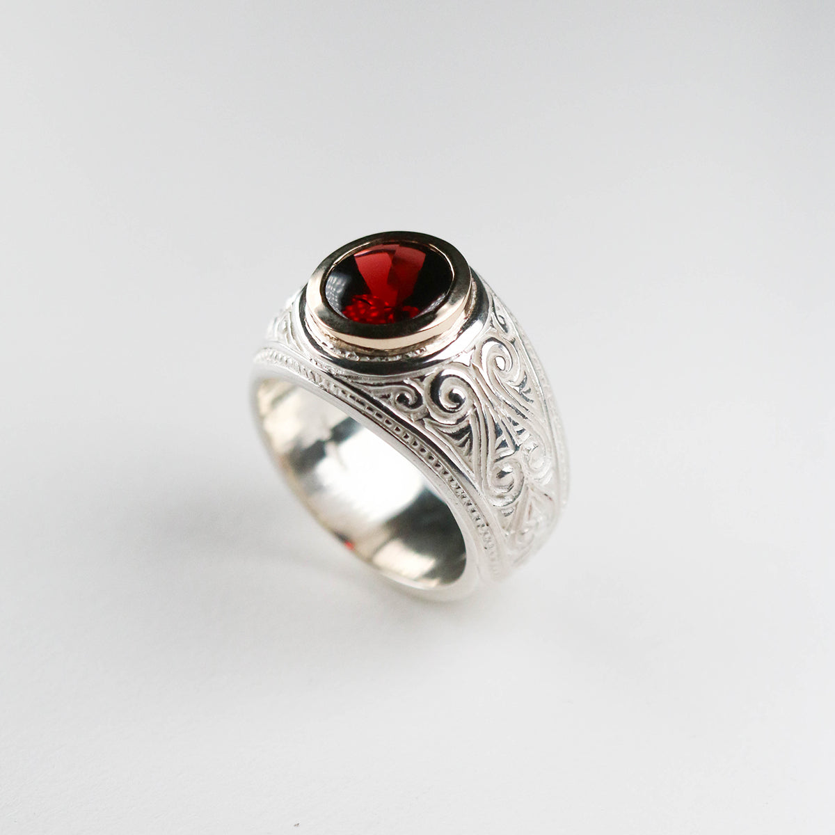 A brand new piece by Jeremy Hoye. This silver college style ring is handmade in solid silver with a 9ct yellow gold setting and oval garnet stone.