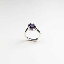 Hand carved in solid silver and finished with textured inlaid detail. This ring holds a rich, round amethyst which sits asymmetrically on the finger.