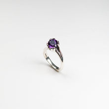 Hand carved in solid silver and finished with textured inlaid detail. This ring holds a rich, round amethyst which sits asymmetrically on the finger.
