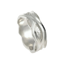 This handmade silver band boasts a 8mm width. Its appeal lies in the fluid oval design with textured inlay, reflecting the unique craftsmanship characteristic of handmade jewellery.