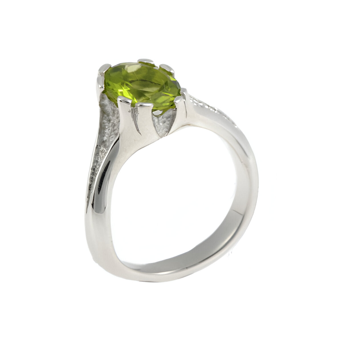 Hand carved in solid silver and finished with textured inlaid detail. This ring holds a rich, round peridot which sits asymmetrically on the finger.