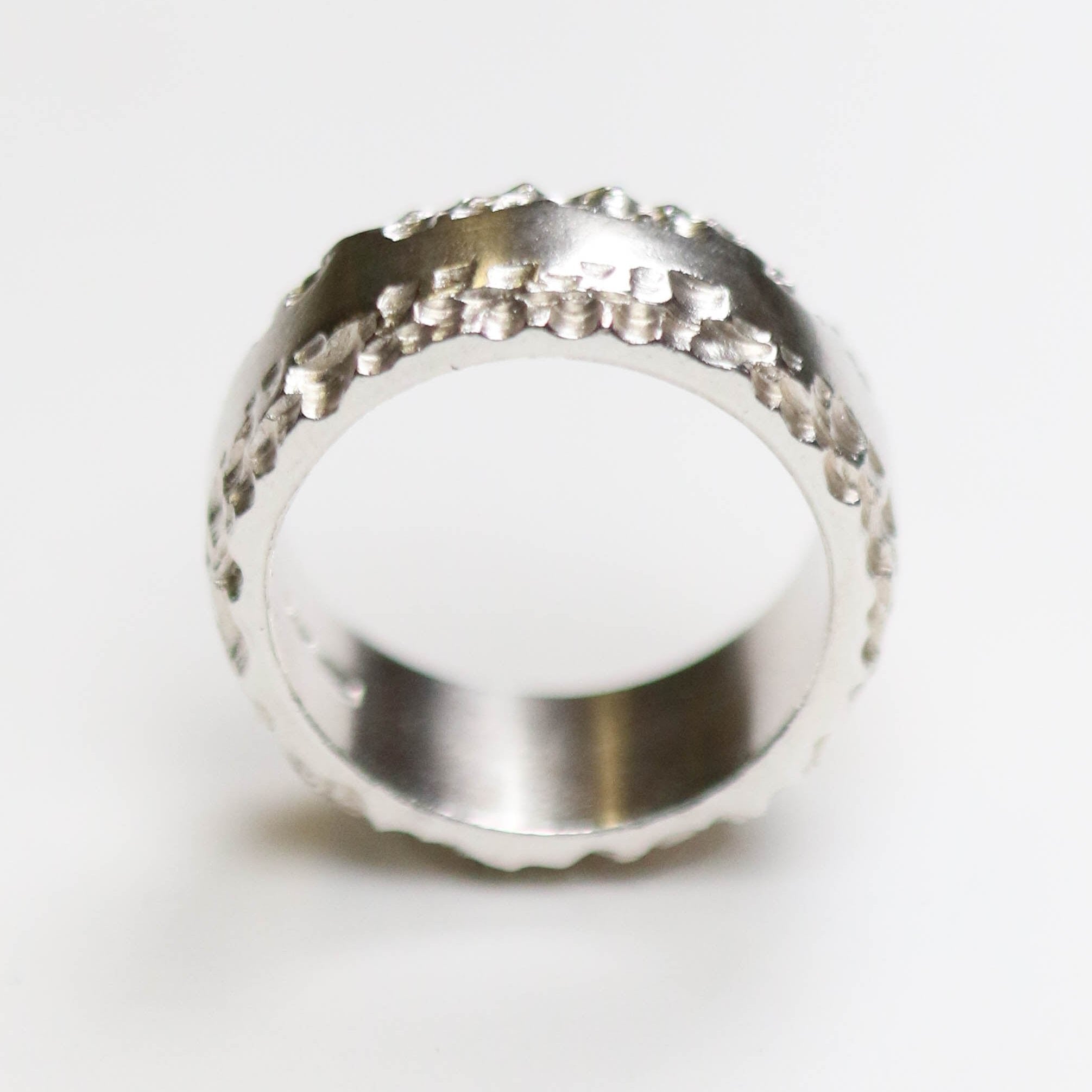 This silver band measures 10mm in width, and features a flat centre with contrasting textured edge.