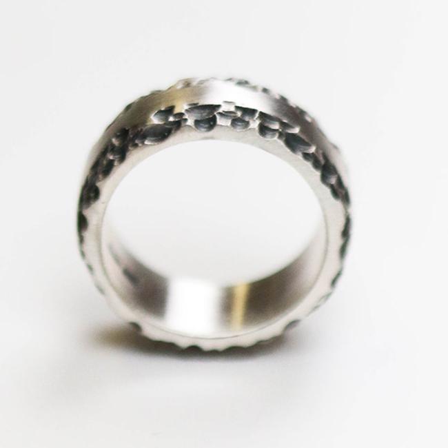 This silver band measures 10mm in width, and features a flat centre with contrasting textured edge.