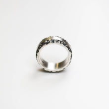 This silver band measures 10mm in width, and features a flat centre with contrasting textured edge.