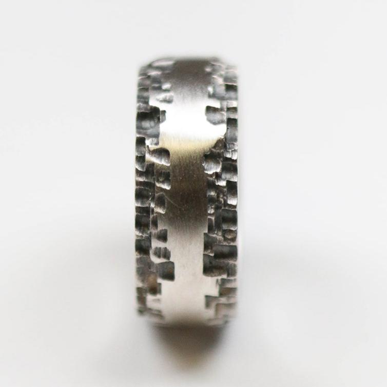 This silver band measures 10mm in width, and features a flat centre with contrasting textured edge.