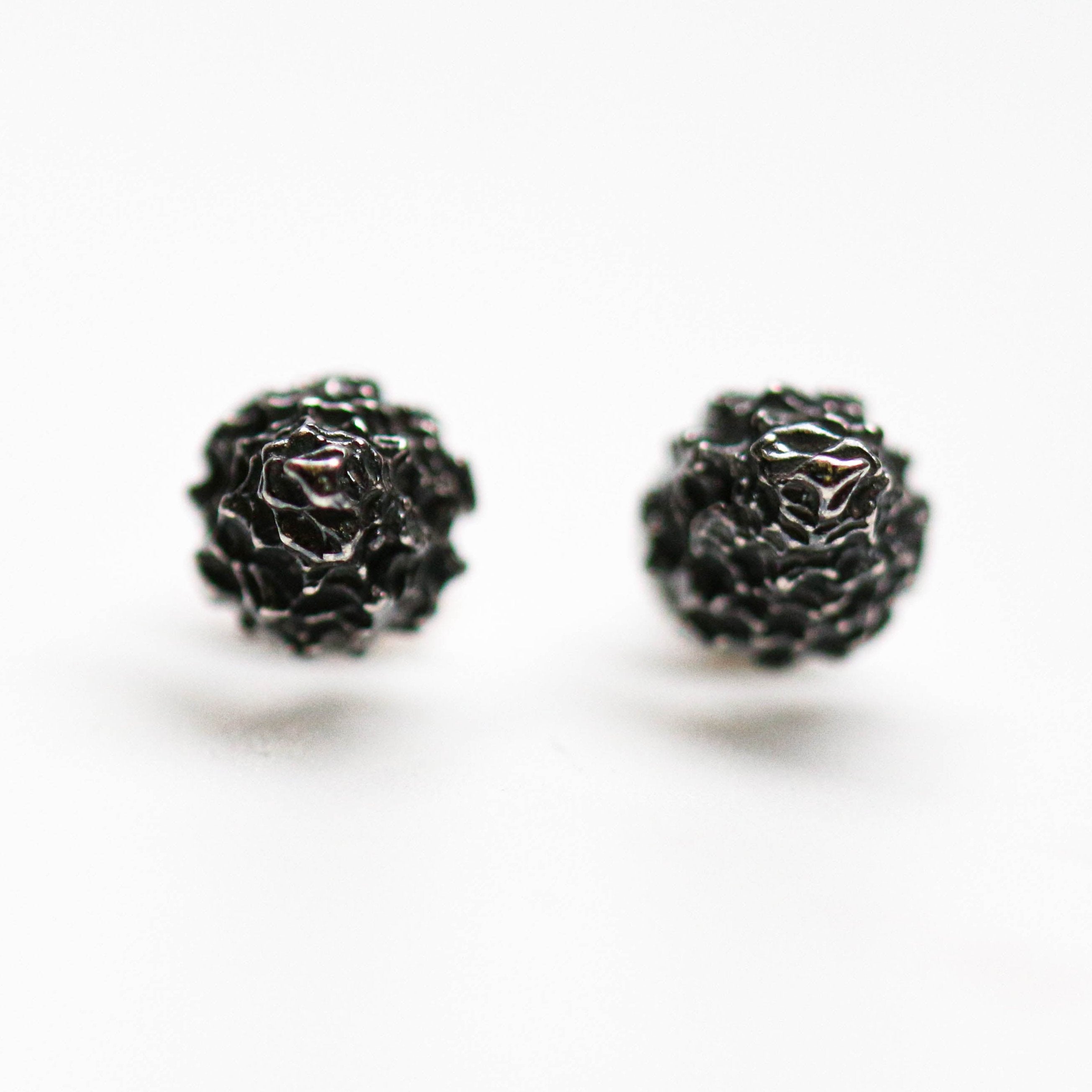 These Cone Lunas come in an oxidised finish. These textured studs measure 7mm wide and 8mm in length.