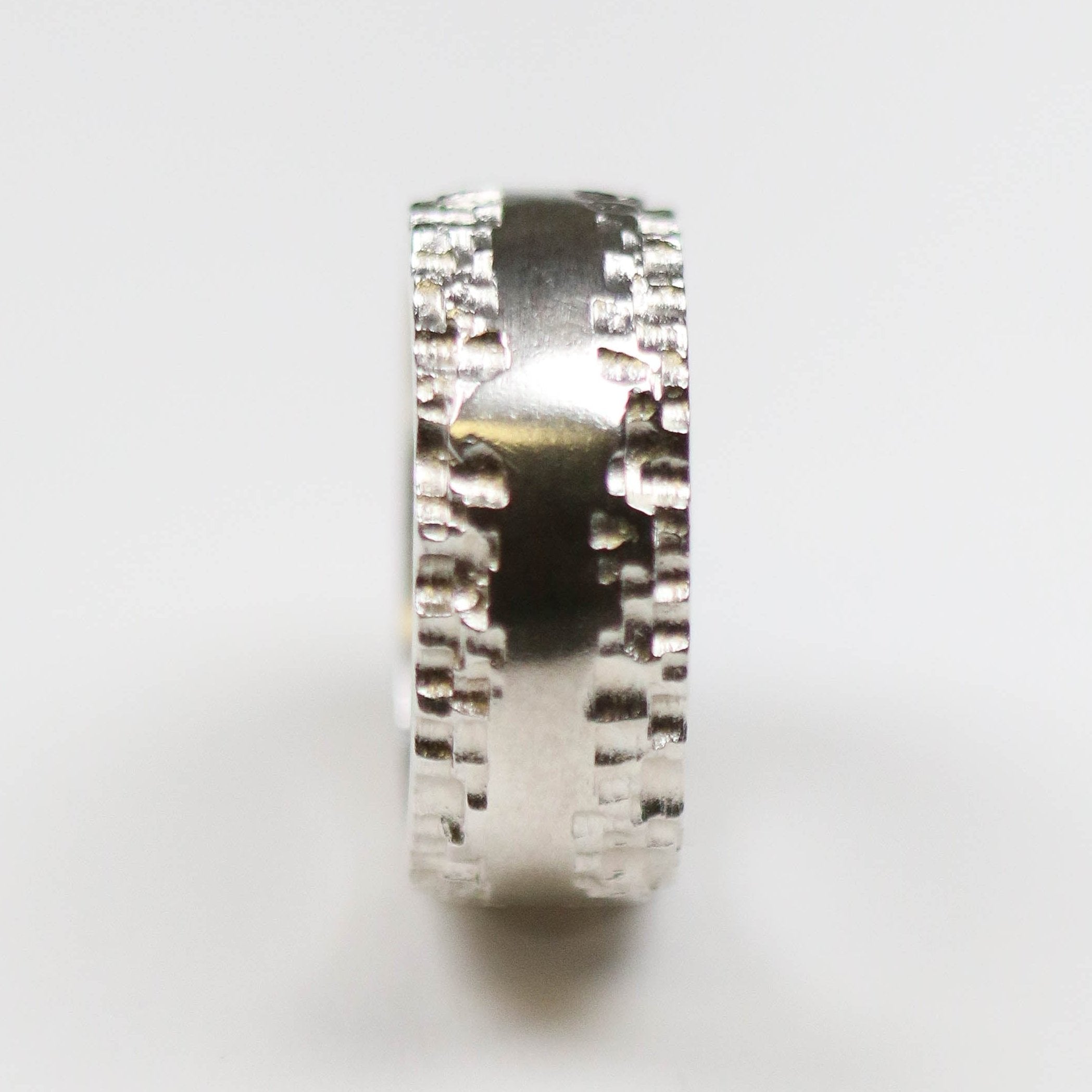 This silver band measures 10mm in width, and features a flat centre with contrasting textured edge.