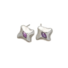 The earrings features a central marquise stone set in silver.