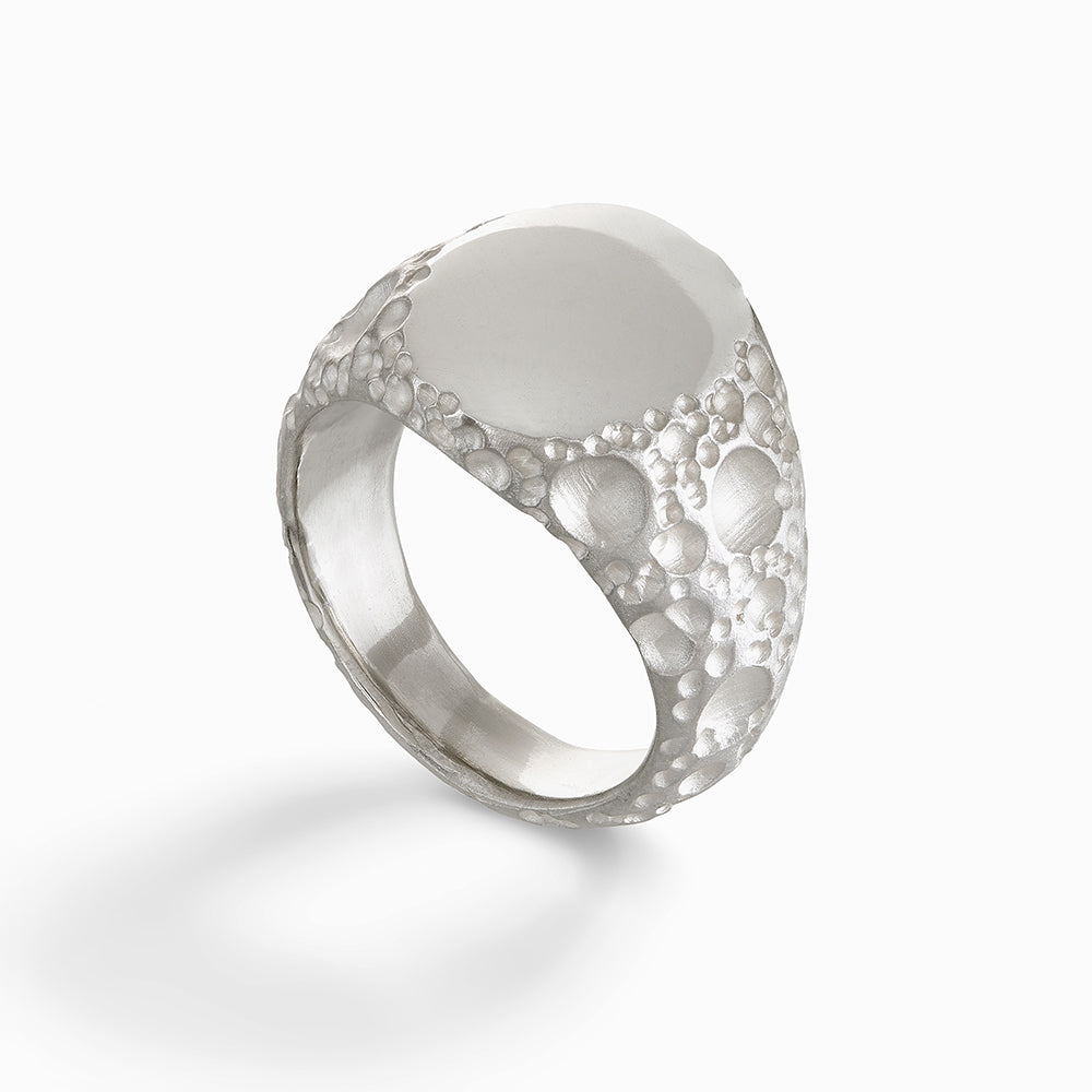 Silver signet ring with moon textured edges.