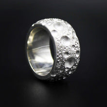 This handmade silver band measures 12mm in width and is finished with unique textured surface detail and a smooth, polished inside for comfort.