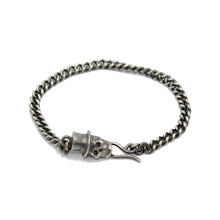 Silver curb link bracelet chain with silver skull in top hat fastening. Measurements are 7 1/4 inches for women and 8 1/2 inches for men.