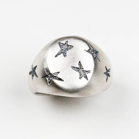 Handmade in silver with scattered inlaid textured star shapes, this ring is designed as an alternative to the traditional style signet ring. the top measures 17mm by 14mm.