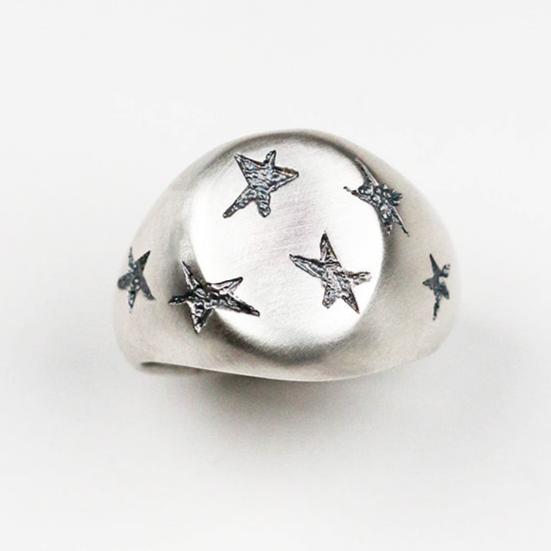 Handmade in silver with scattered inlaid textured star shapes, this ring is designed as an alternative to the traditional style signet ring. the top measures 12mm by 10mm.