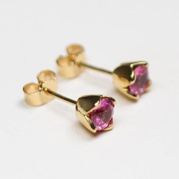 Handmade in 18ct yellow gold and set with two round pink sapphires totalling 1.10ct.