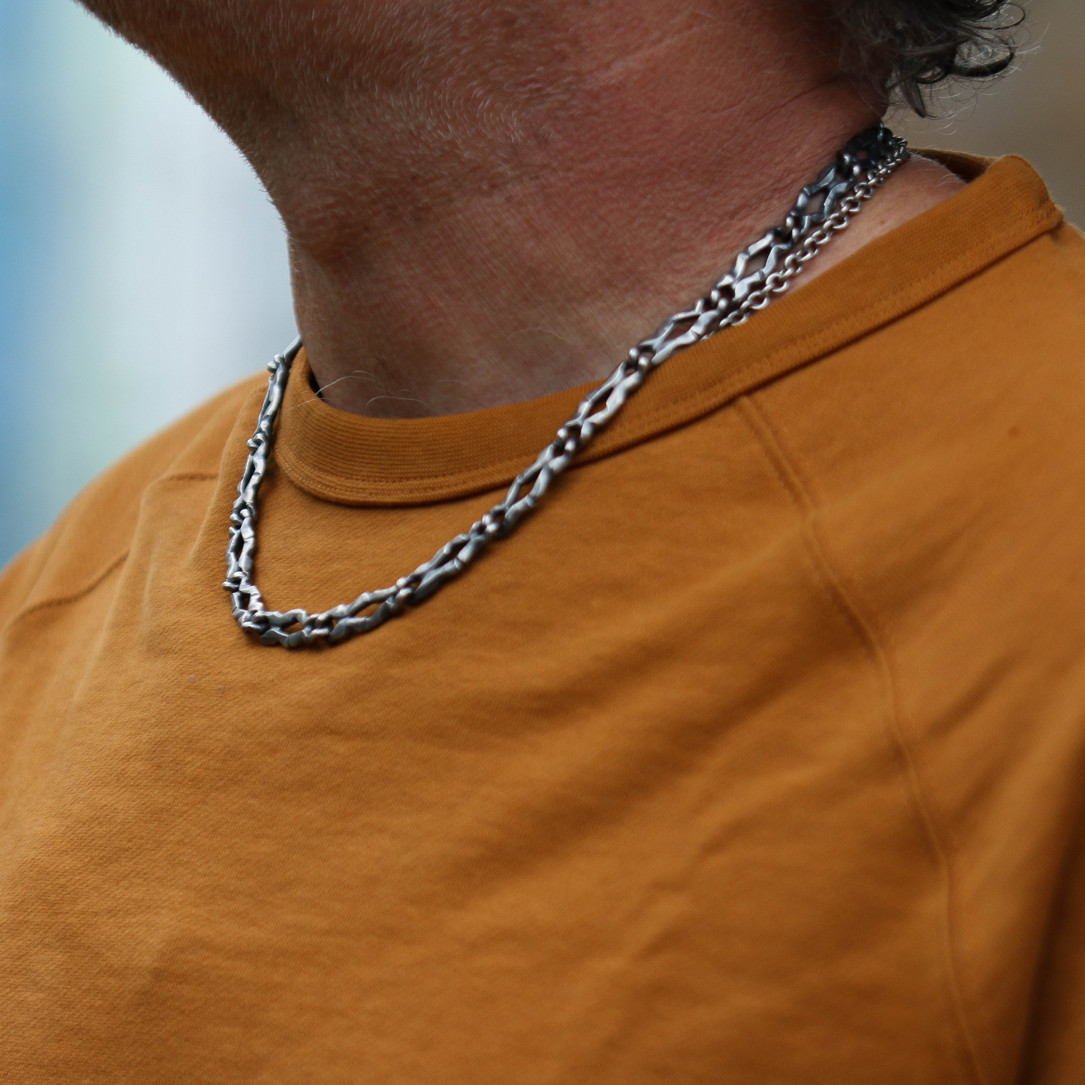 Jeremy wearing a carved link necklace